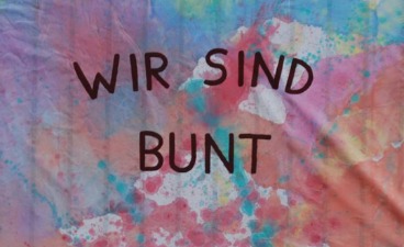 Sommerfest im BTZ Braunschweig-Wolfsburg Foto eines bunt bemalten Tuchs mit der Aufschrift "Wir sind bunt": Sommerfest im BTZ Braunschweig-Wolfsburg